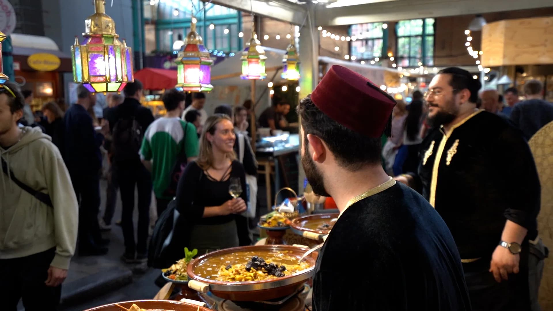 Gäste warten am Stand, während marokkanische Laternen darüber hängen