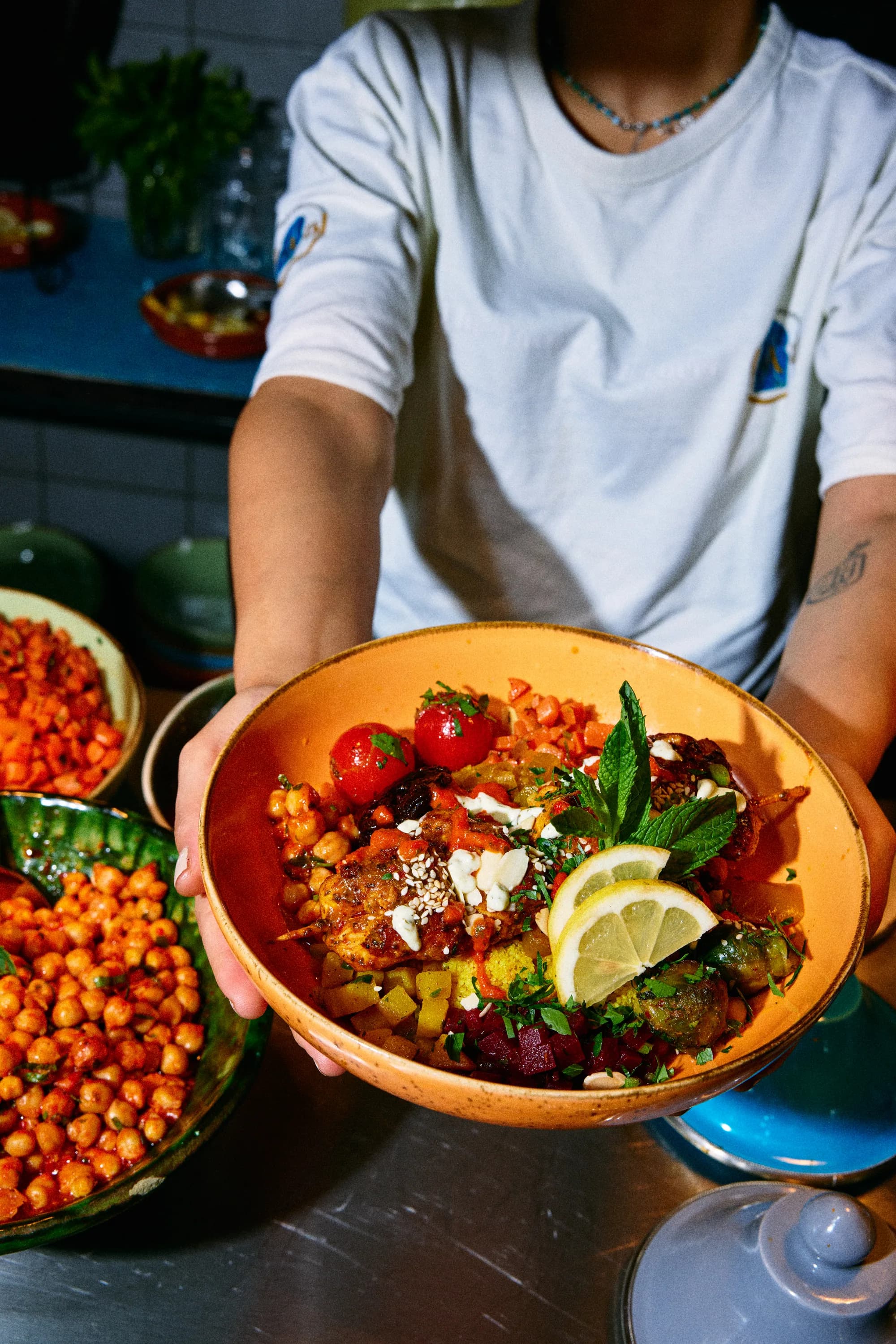 A person holding a filled couscous bowl towards the camera