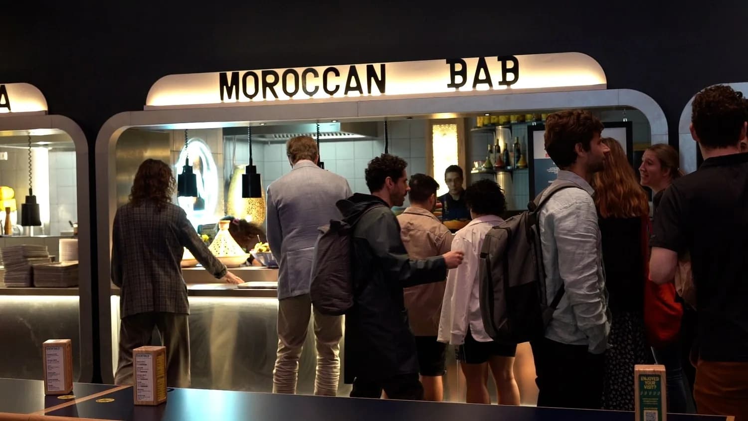 Der beleuchtete Stand „Moroccan BAB“ in der KERB Berlin, davor eine Schlange wartender Gäste