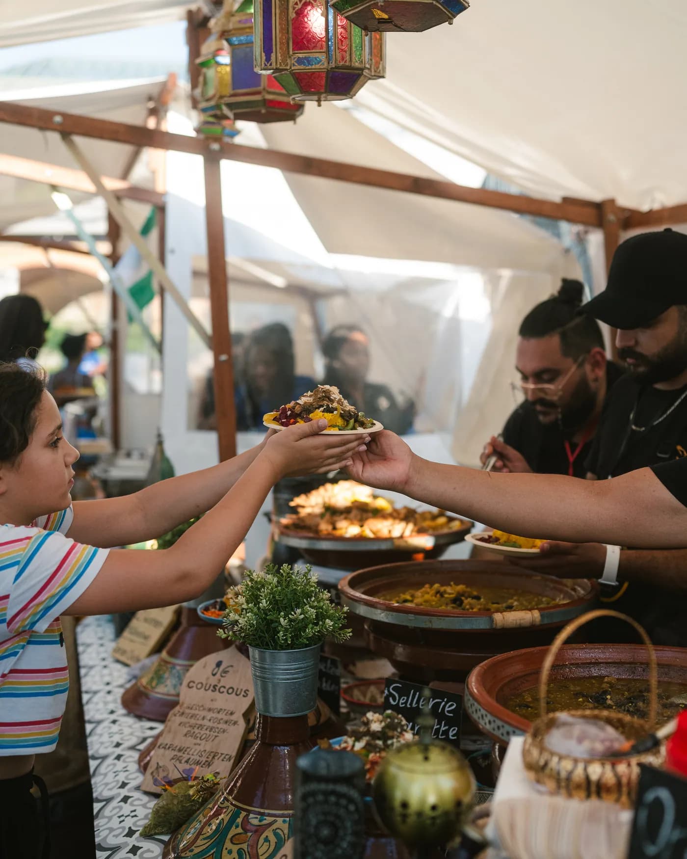 A child receiving a plate of couscous at the counter